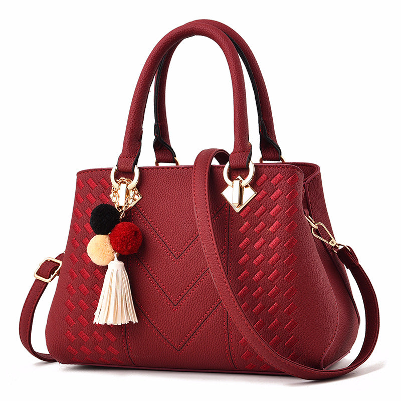Embossed handbag with pompom charm