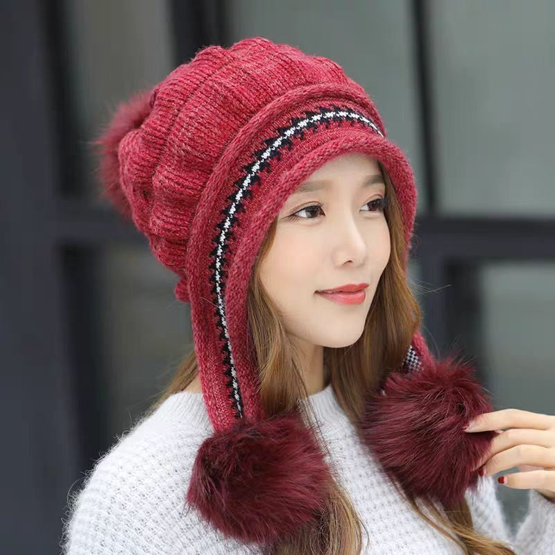 Woman in an ear flap beanie with pompom